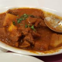 Goat Vindaloo · Tender cubes of goat with potatoes cooked in a fiery hot curry sauce. Served with rice.