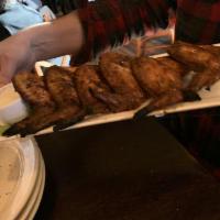 Woodfire Buffalo Wings · Six whole wings rubbed with signature herbs and spices, roasted over an open flame and brush...