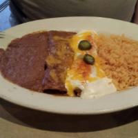 Beef Enchiladas · Ground beef enchiladas topped with chile con carne served with rice and beans.