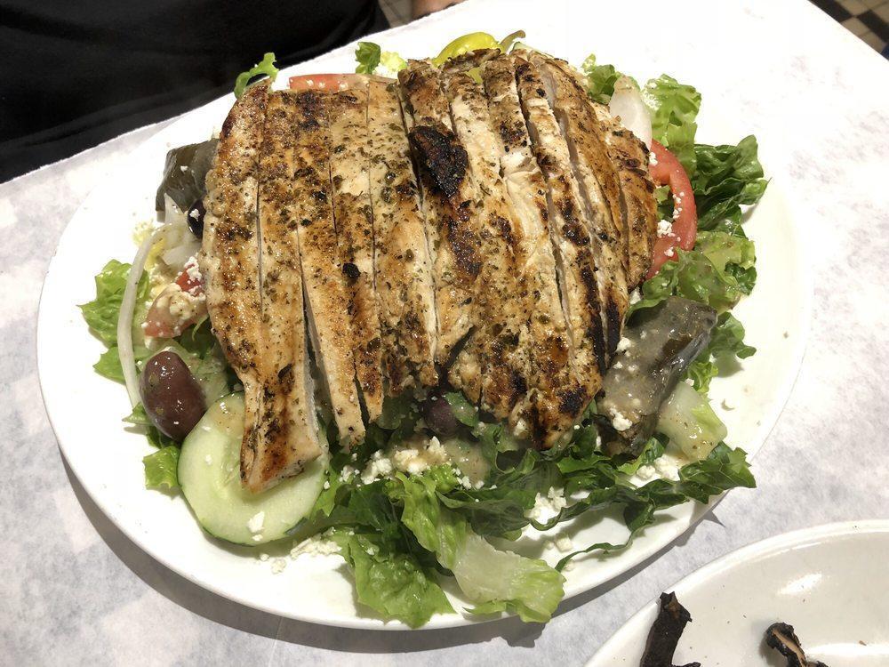 Greek Salad · Lettuce, tomatoes, cucumbers, onions, olives, pepperoncini, dolmades, crumbled feta, and vinaigrette dressing.