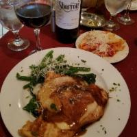 Saltimbocca · Veal or chicken topped with prosciutto, mozzarella and sausage in a wine demi-glaze on a bed...