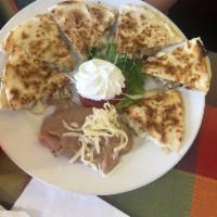 Chicken Quesadilla · Pan seared flour tortillas with mozzarella and chicken. Includes a side of refried beans and...