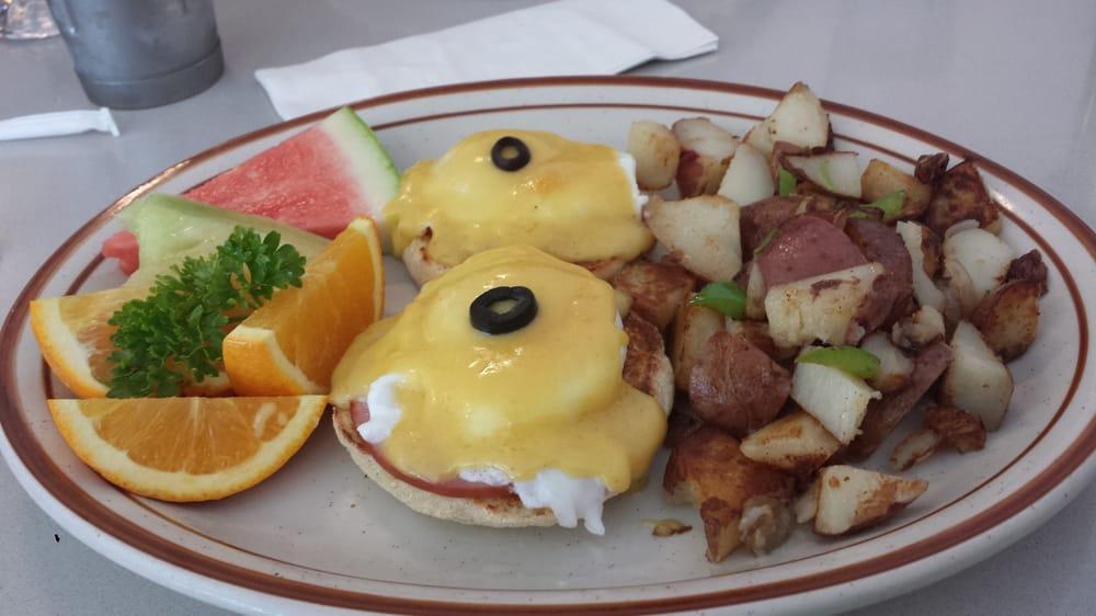 Eggs Benedict · two Poached eggs on English muffin, Canadian bacon, topped with hollandaise sauce & fruit. home country potatoes or hash browns .