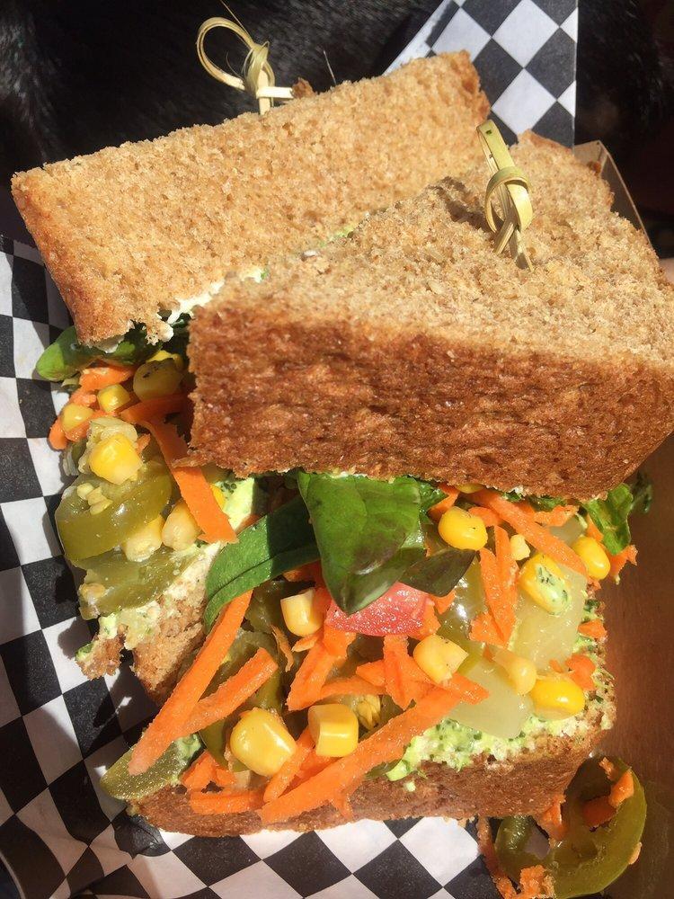 Veggie Sandwich · Ricotta cheese, carrot, corn, olives, pineapple, jalapeno, lettuce, tomato, avocado, grilled onions and cilantro garlic sauce served on whole wheat bread. Vegetarian.