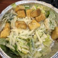 Caesar Salad · Romaine lettuce tossed with a Caesar dressing topped with homemade croutons and shaved pecor...