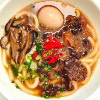 Niku Udon Soup · Udon noodles served hot with ribeye beef, sliced green onions, shiitake mushrooms, pickled g...