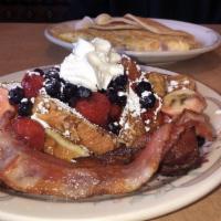 Very Berry French Toast · Topped with strawberry compote, blueberries, slices of banana, whipped cream and served with...