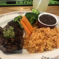 Carne Asada · Skirt steak topped with chimichurri sauce served with rice, beans and vegetables.