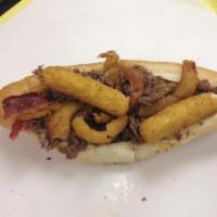 Fat Hornet · Large cheesesteak sub, cooked with onion rings, bacon, mozzarella stickes, choice of sauce.