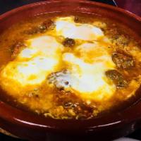 Shakshuka · Poached eggs, tomato sauce, chili peppers and onions served in tagine. Add mini Moroccan mea...