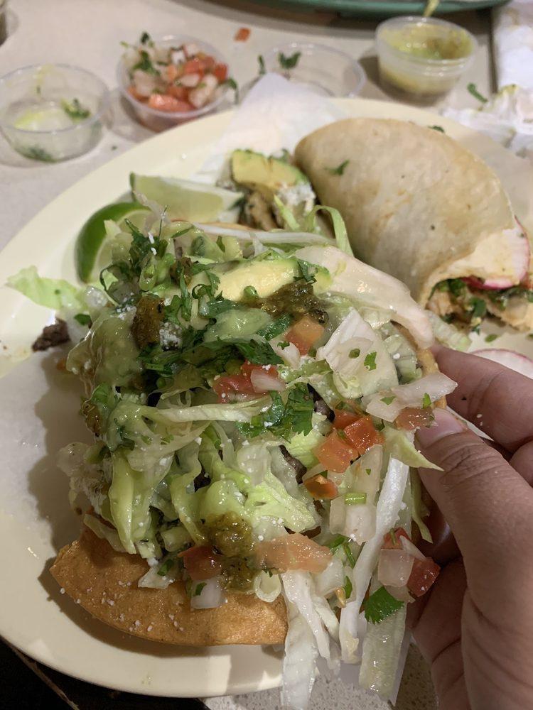 Tostada · Homemade Crispy tostada coated with refried beans and topped with lettuce avocado and Cotija cheese.