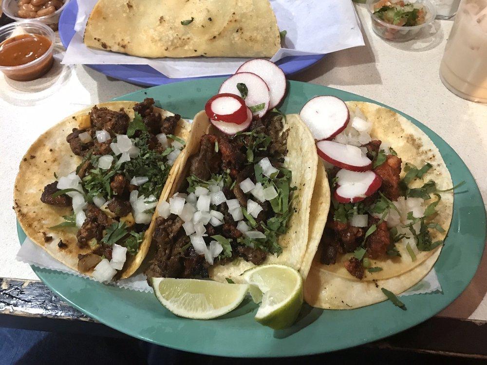 Al Pastor Taco · Marinated pork with grilled pineapple and onions. Tacos topped with fresh onions and cilantro, garnish with a lime wedge and radish.
