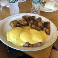 Eggs Benedict · 3 poached eggs on toasted English muffin and ham covered in hollandaise sauce and served wit...