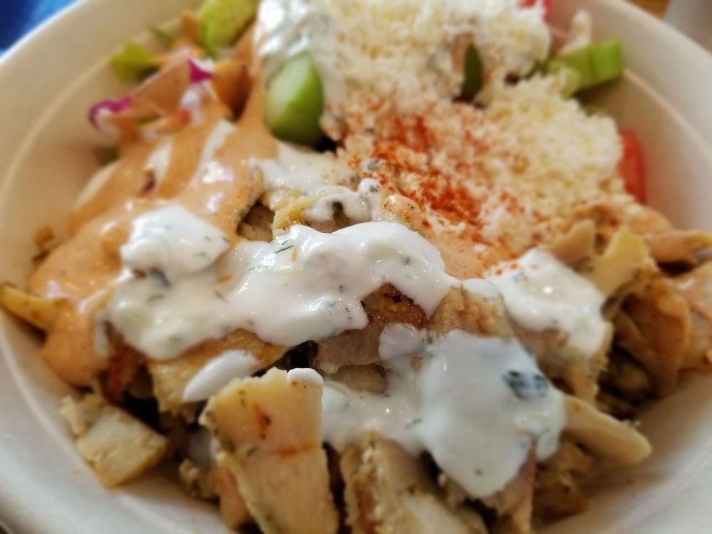 Gyro Bowl · Choice of any meat or falafel, basmati rice, romaine lettuce, onions, tomatoes, English cucumbers, feta and red wine vinaigrette topped with tzatziki and spicy yogurt.
