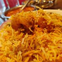 Shrimp Biryani · An aromatic mixture of basmati rice, shrimp, saffron, herbs and spices, served with raita an...