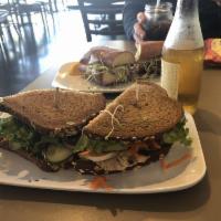Farmer's Market Sandwich · A garden sandwich on 9-grain bread piled high with avocado, sunflower seeds, sliced pickles,...