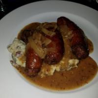 Bangers and Mash · Irish pork sausages, topped with Guinness onion gravy, served with colcannon potatoes and ba...