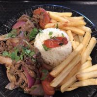 Lomo Saltado · Tender steak with onions and tomatoes served over french fries and rice.