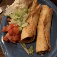 Flautas · Two flour tortillas filled with chicken, quickly fried. Served with lettuce, tomatoes and so...