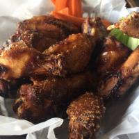 Smoked Wings · Smoked for hours in house on our Traeger, then flash-fried and tossed in your choice of dry ...