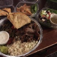 Gyro Plate · Sliced gyro served on a bed of rice pilaf and vegetables. Served with a dinner salad, a cup ...