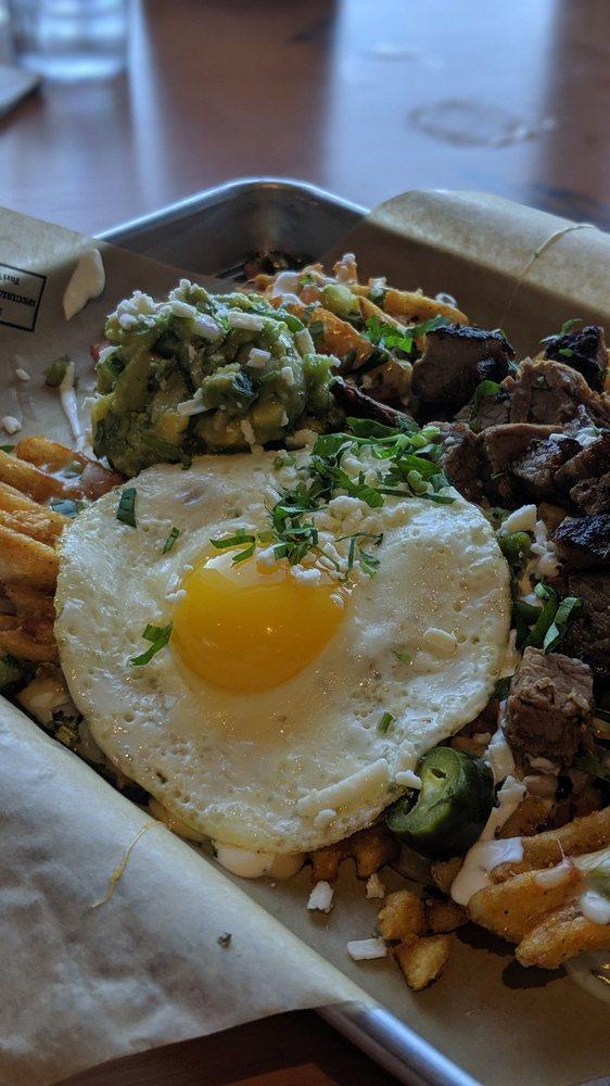 Trash Frys · Waffle fries, sunny side up egg, cheddar Jack blend queso, pico, jalapenos, tequila crema and Cotija cheese. Add bacon, pork, chicken or brisket for an additional charge.