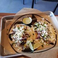 Smoked Carnitas Tacos · Smoked pulled pork red onion, jalapenos, green Chile ranch, jalapeno slaw, tequila crema, Co...