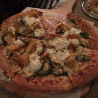 Spinach and Artichoke Pizza · Fresh spinach and artichoke hearts over garlic herb sauce, topped with ricotta and mozzarella.