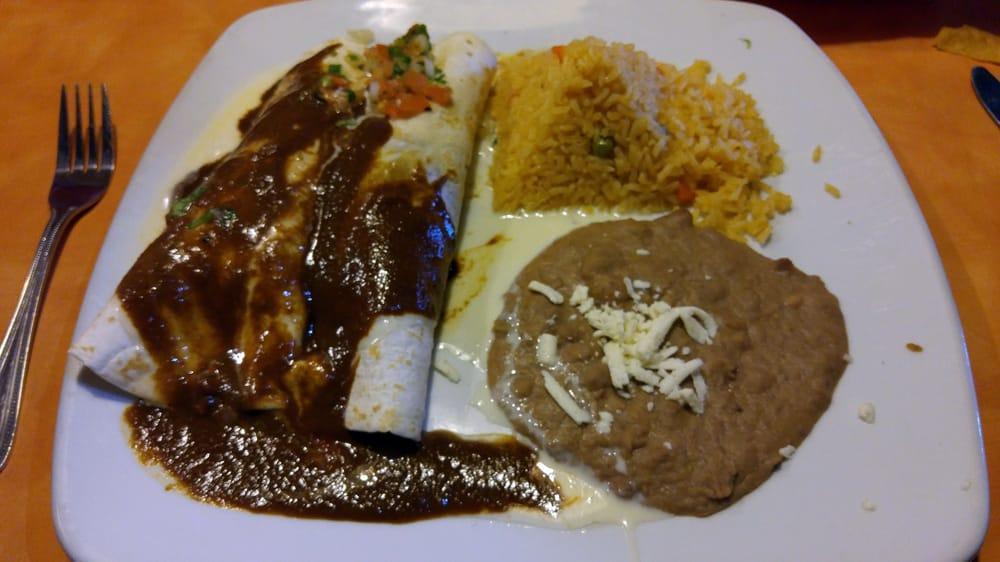 Burrito De La Roqueta · 2 soft flour tortillas filled with an exquisite choice of chicken or pork, topped with creamy melted cheese, pico de gallo and famous mole sauce! side refried beans or Mexican rice.