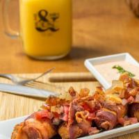 Bacon Wrapped Tamales · House made corn tamales wrapped in bacon topped with chalice sauce and porkbelly chunks serv...