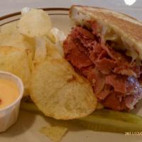 Traditional Reuben Sandwich · Hot corned beef on grilled rye, Swiss cheese and sauerkraut.