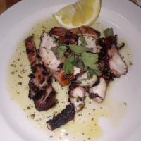 Grilled Octopus · Char-grilled Spanish octopus, lemon vinaigrette and oregano on a bed of salad greens.
