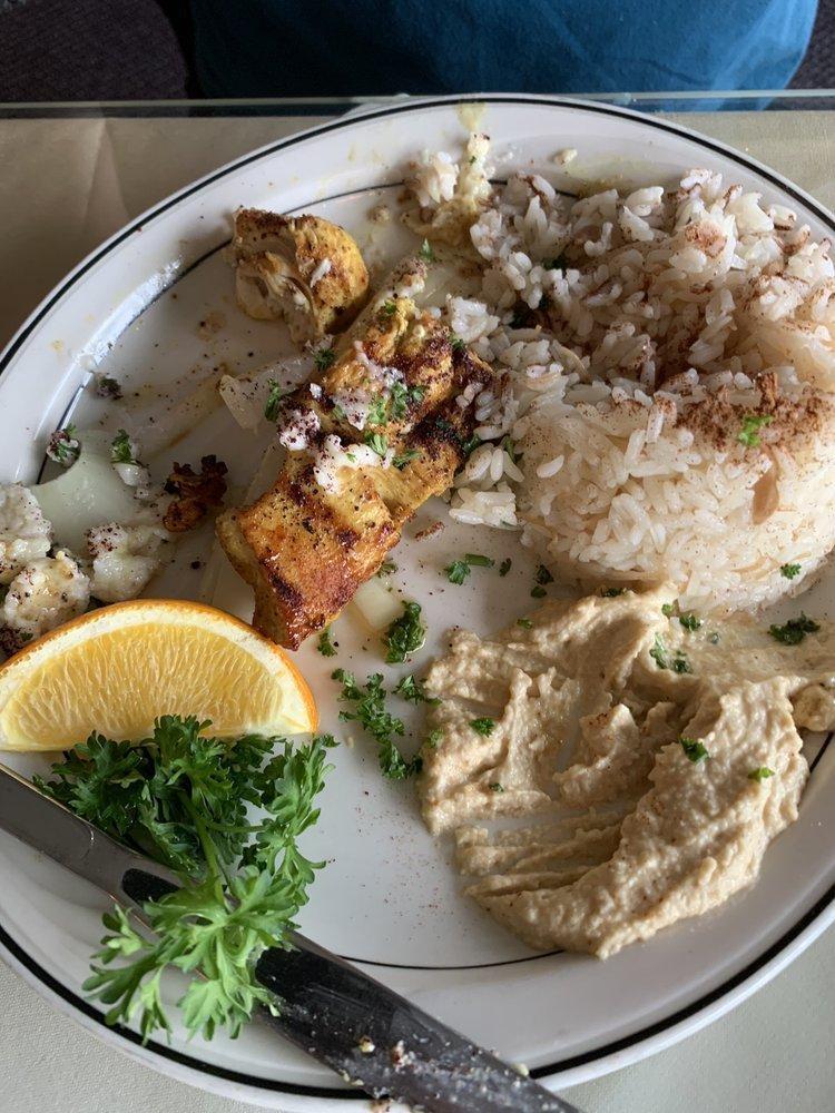Shish Tawouk · Lemon and garlic chicken pieces cooked to perfection, served on a bed of onions, with hommous.