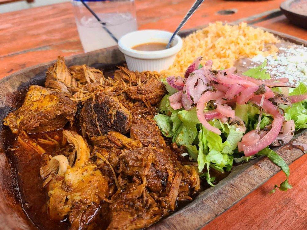 Cochinita Pibil · Served with rice, beans and hand made tortillas. Traditional Mayan dish is slow cooked marinated pork with achiote flavor plus a variety of Mayan herbs. Served with green leaf lettuce, pickled red onions and a side of habanero sauce.