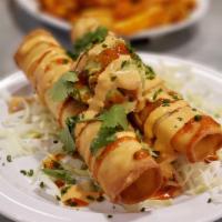 Lobster Taquitos · 2 pieces. Flour tortilla deep fried and topped with guacamole. Sauce served on the side.