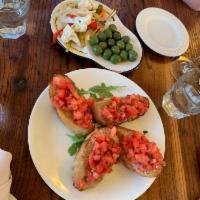 Bruschetta · Four slices of our homemade bread toasted in the pizza oven and topped with diced tomato, ba...