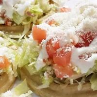 Sopes · Refried beans, fresh onion, cilantro, lettuce, tomatoes, sour cream, cheese, and your choice...
