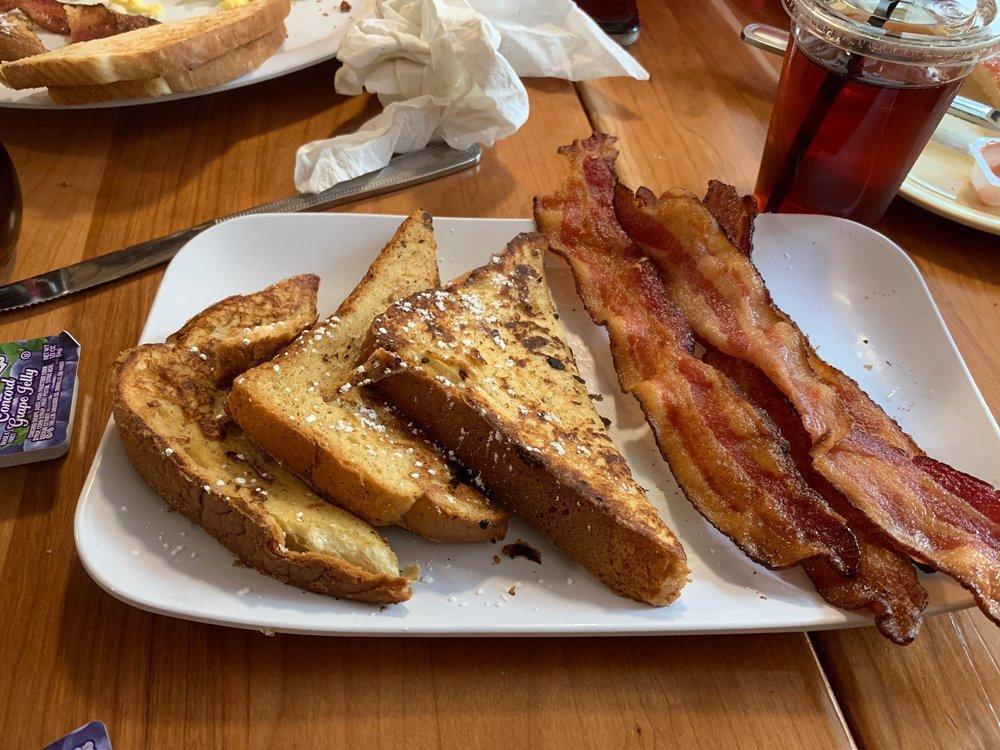 Brioche French Toast · Buttery brioche bread dipped in spiced custard and grilled, finished with powdered sugar. Served with applewood-smoked bacon.