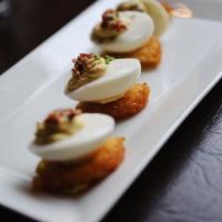 Deviled Eggs · Red pepper harissa, hash brows, applewood-smoked bacon and chives.