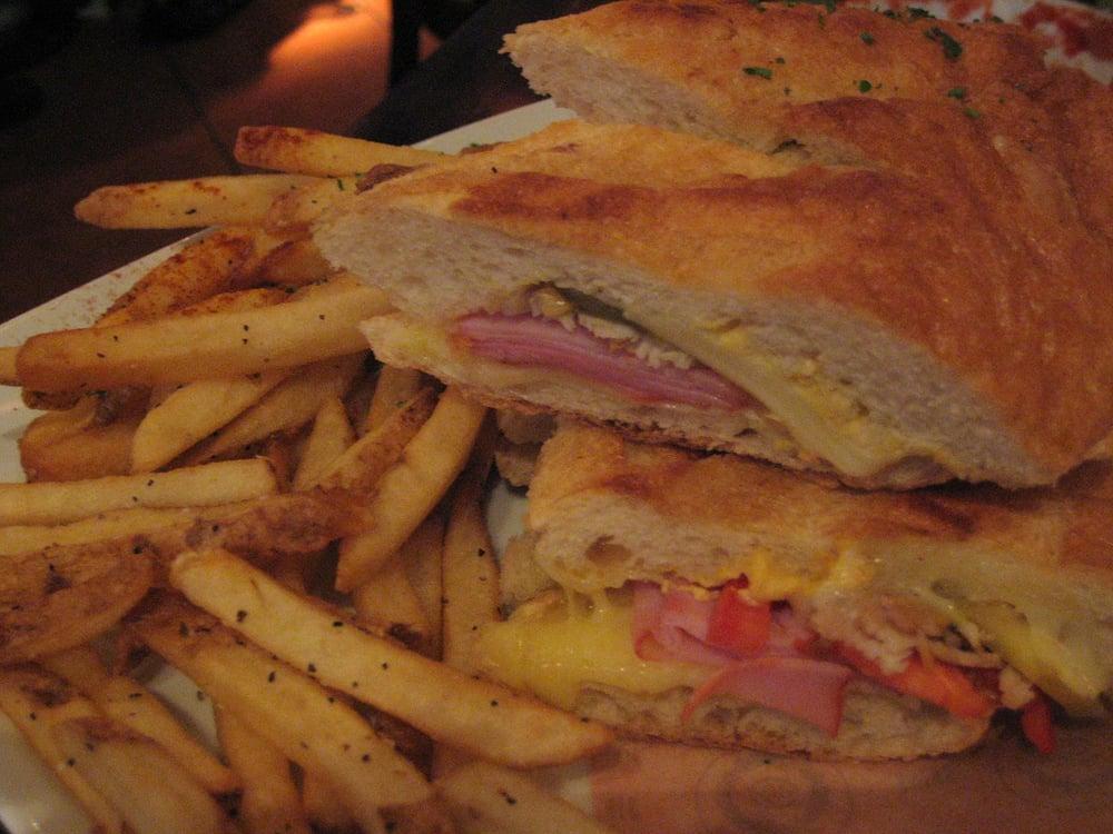 Torta Cubana Sandwich · Grilled french baguette with sliced tomatoes, gruyere cheese, baby Swiss, honey ham, roasted pork shoulder, pickles. Mayo and mustard.