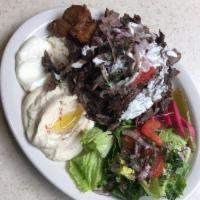 Beef Shawarma Plate · Topped with tomatoes, onions and tahini sauce. Includes salad, hummus, garlic paste, potatoe...