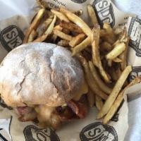 The 3 Little Pigs Burger · House ground pork topped with bacon jam, thick cut bacon, cheese sauce and Sri-Rancha sauce ...