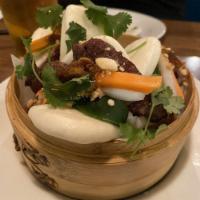 Grilled Pork Bao · Grilled lemongrass pork, cilantro, pickled vegetables, topped with crispy shallots and crush...