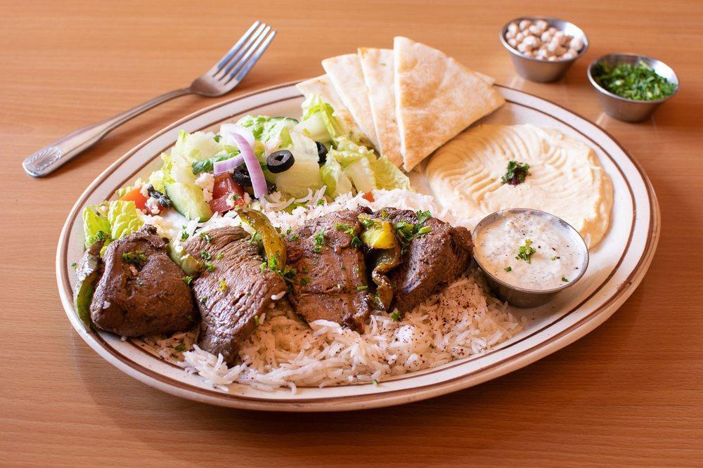 Filet Mignon Kabob · Marinated and spiced filet mignon cubes, grilled over fire. Served with rice, hummus, Greek salad, onions, pita bread and tahini sauce. Decorated with parsley and sumac.