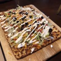 Tostada Pizza · Spicy ground sirloin, sausage, refried beans, pico de gallo, lettuce, black olives, cheese, ...