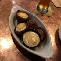 Scotch Eggs Plate · A pair of hard boiled eggs, wrapped in our house blended sausage, golden fried and served wi...