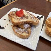 Coconut French Toast · 3 slices garnished with strawberries, bananas, powdered sugar, and blueberry puree. Make it ...