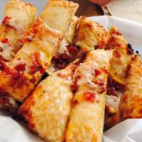 Bacon Cheddar Breadsticks · Our garlic breadticks topped with a sprinkle of bacon and a touch of cheddar. Served with pi...