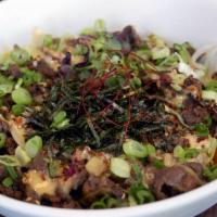 Bulgogi Dupbab · Soy marinated beef and mixed vegetables on rice with crispy quinoa, iceberg lettuce, chili s...