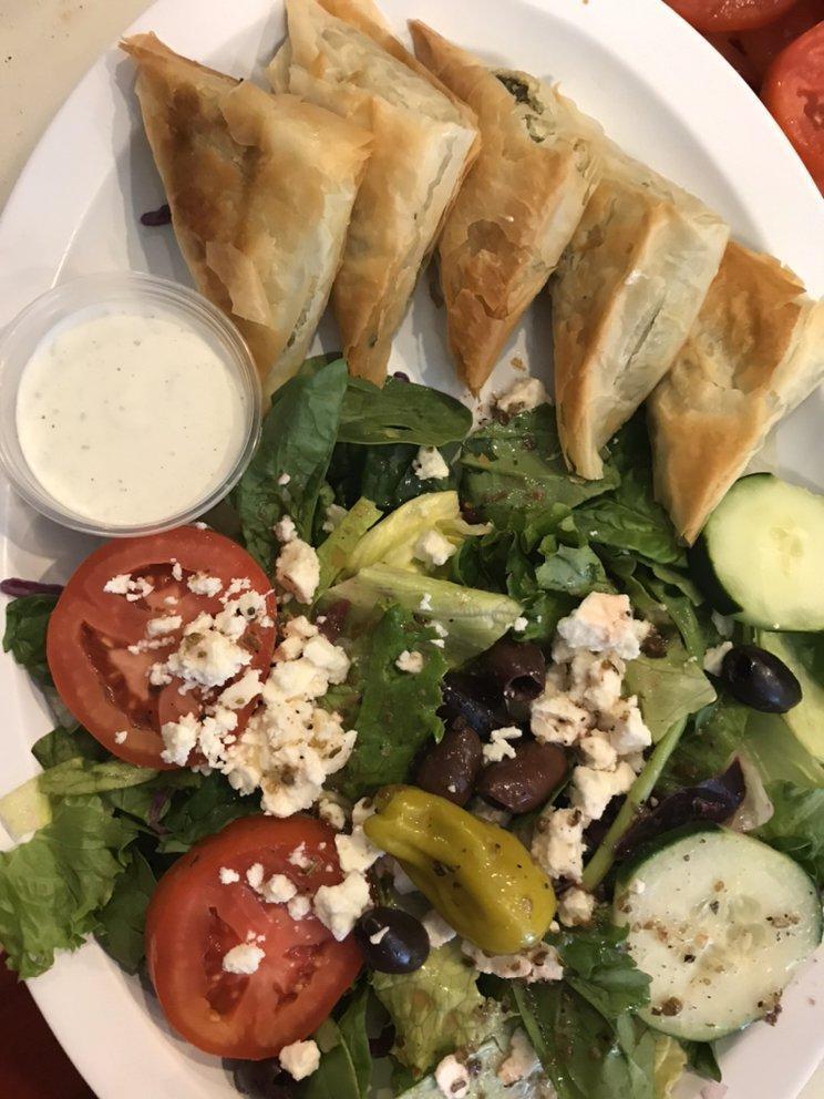 Spanakopita · 2 phyllo triangles stuffed with chopped spinach, onions, ricotta and feta cheese. Served with a fresh Greek salad and homemade Tzatziki sauce.